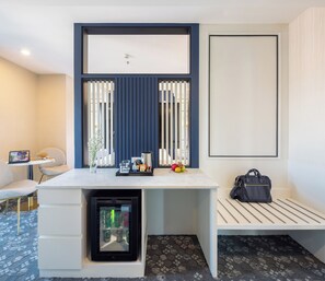A hotel room with a desk, a bench, a minibar, and a wall-mounted shelf. - Eastin Hotel Vientiane Laos (Vientiane)
