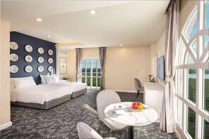Habitación de hotel con cama, escritorio, silla y mesa con fruta.
