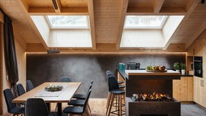 A modern kitchen with a central island, skylights, and a wood-paneled ceiling. - Chalet (LA VALLE)