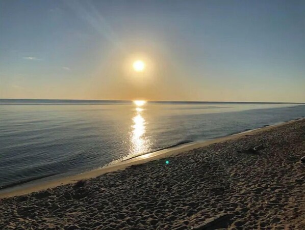 En strand med ett lugnt hav och en klar himmel.