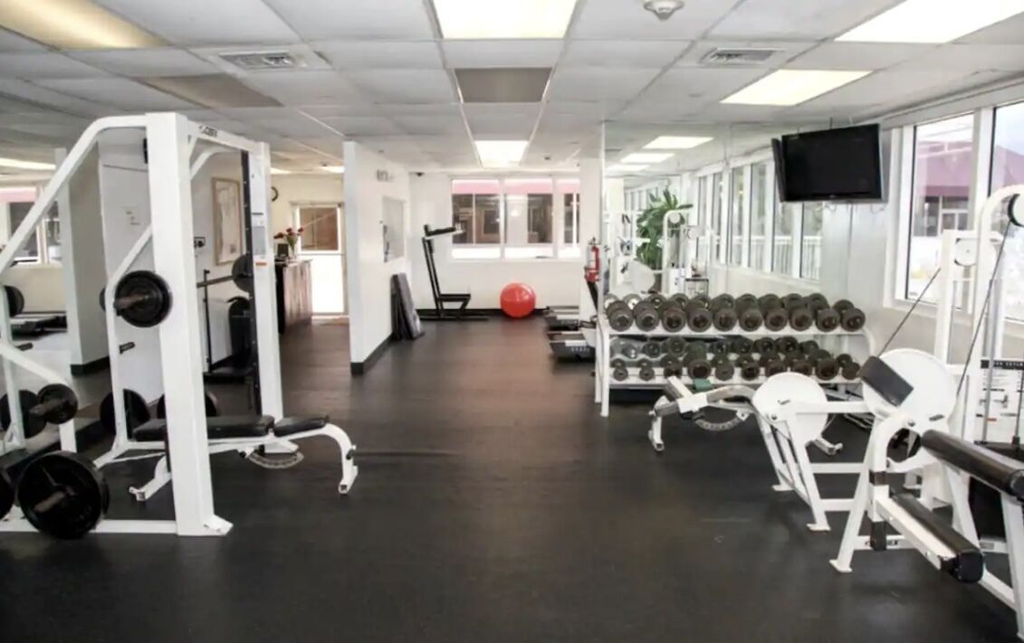 A gym with various exercise equipment, including weight machines and dumbbells.