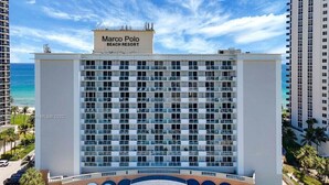 Un hotel a più piani con un cartello ben visibile che riporta la scritta 'Marco Polo Beach Resort'.