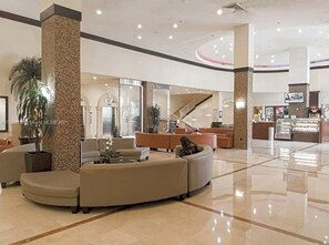 Relax in our spacious lobby, featuring a curved seating area with sofas and armchairs.