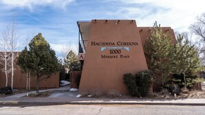 A building with a sign reading "Hacienda Cordova 1000 Marquez Place". - Casita De Alces by Kokopelli Property Management (Santa Fe)