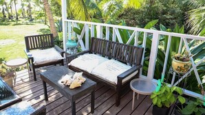 A wooden deck with a bench, a table, and potted plants. - Tangerine Sunsets Castaway, Tangerine Sunsets Castaway (Nassau)