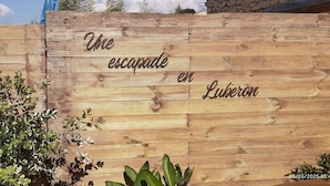 A wooden sign with the text "The escape in Luberon" and a timestamp of "26/03/2025 13:44".