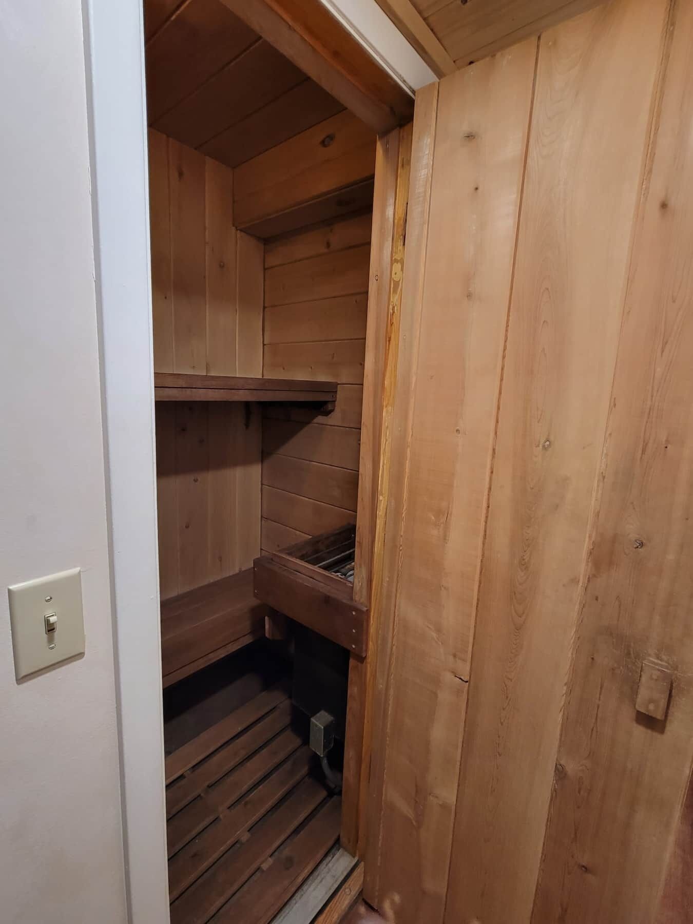 A wooden interior with a built-in bench and a small shelf.