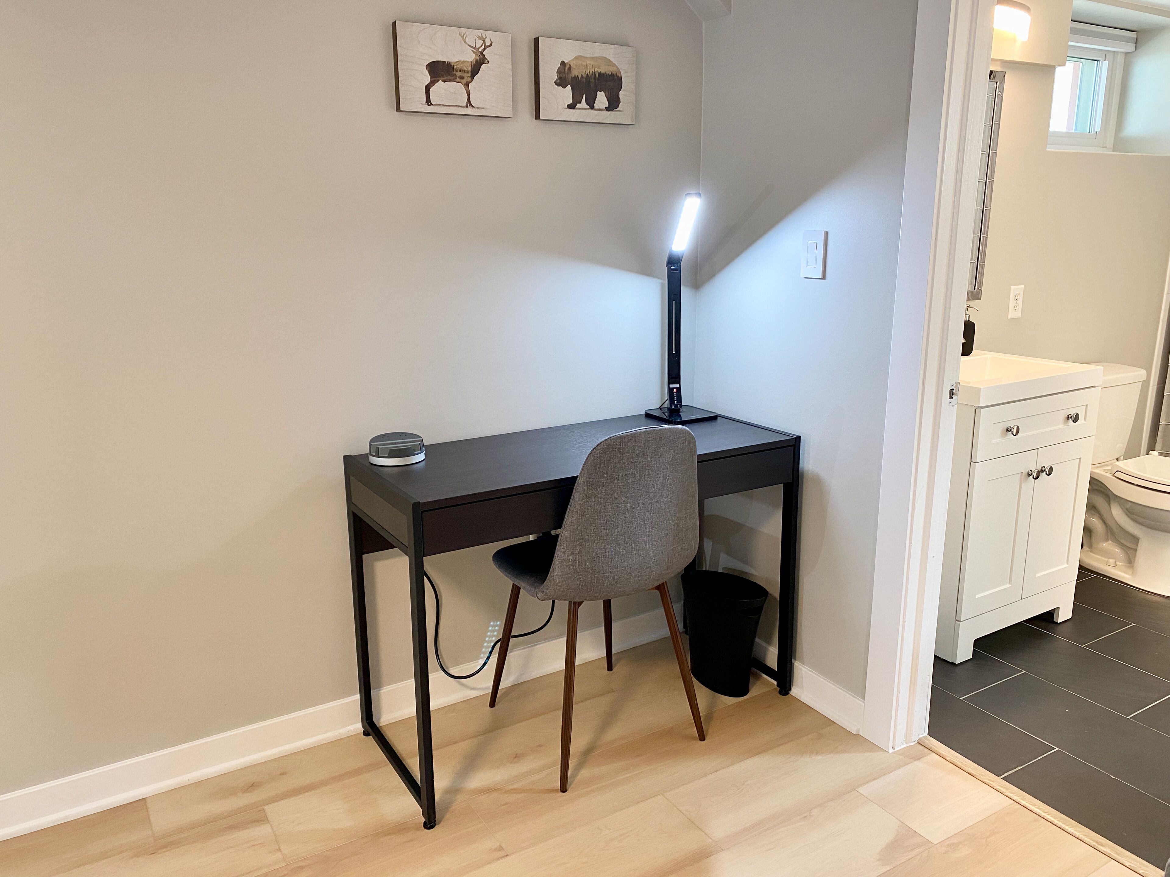 Ein kompakter Arbeitsbereich mit Schreibtisch, Stuhl und Stehlampe.