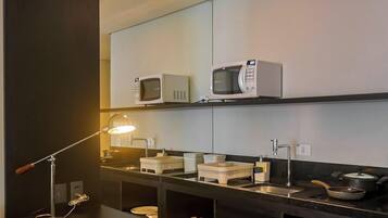 A modern kitchen with a microwave, sink, and stove.