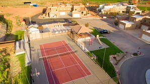 An aerial view of a residential area with a tennis court, houses, and a playground. - Best Rental in Town. (Moab)