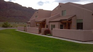 A modern building with a flat roof, large windows, and a well-maintained lawn. - Best Rental in Town. (Moab)