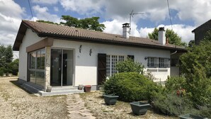 A single-story house with a tiled roof, a chimney, and a small front porch. - House (Hourtin)