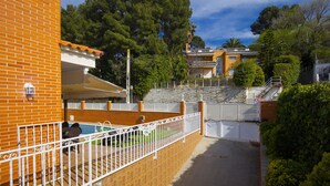 Un quartier résidentiel comprenant un immeuble en briques, une piscine et une entrée sécurisée par un portail.