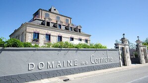 Een groot, historisch gebouw met een stenen gevel en een bord met de tekst 