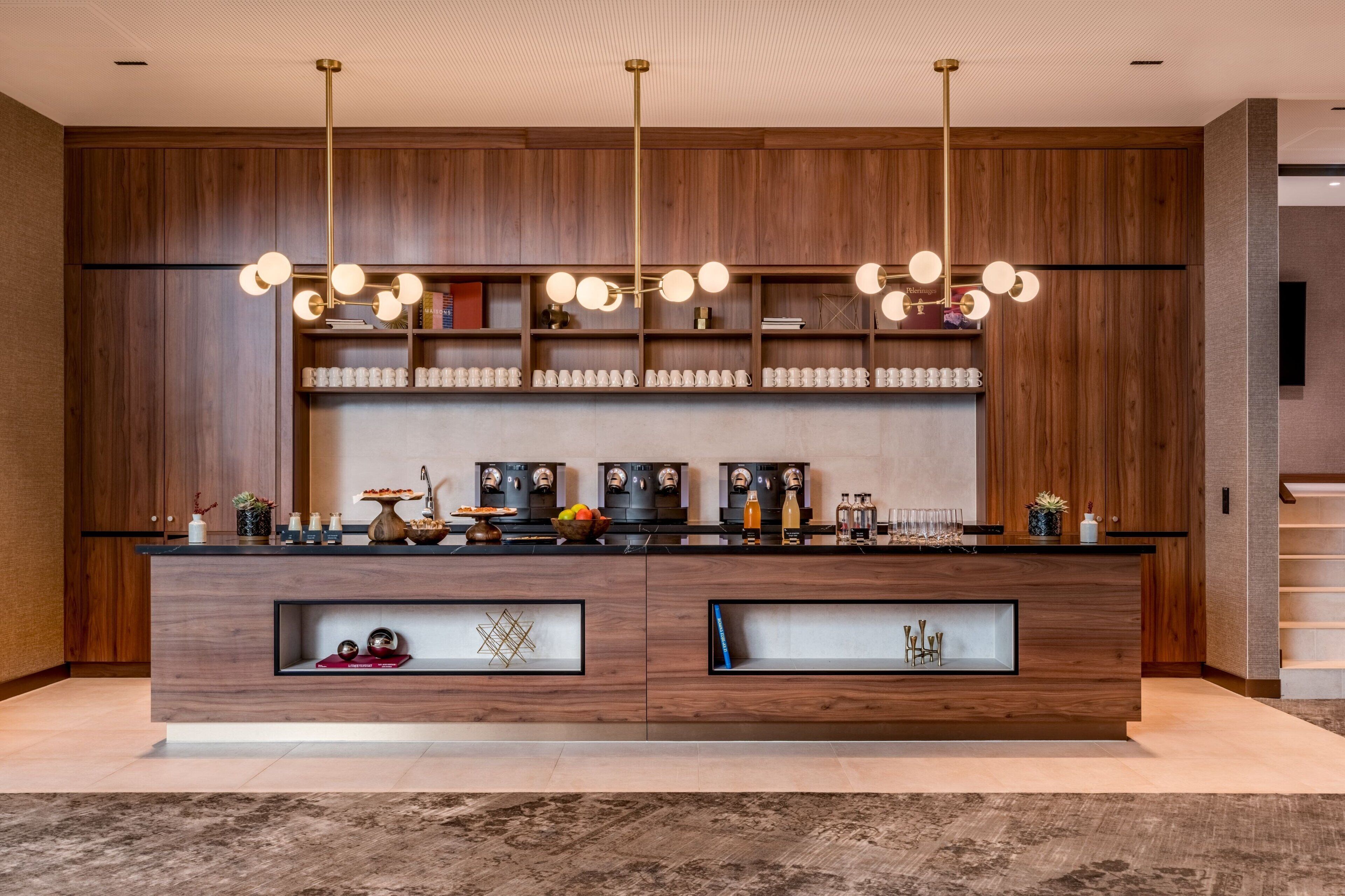 A modern kitchen with wooden cabinetry, a central island, and pendant lighting.