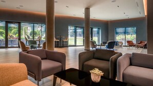 Un vestíbulo espacioso con muebles modernos, ventanas amplias y vistas al exterior.