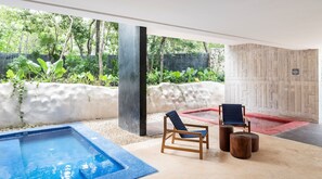 A pool area with a wooden deck, two chairs, and a small table.