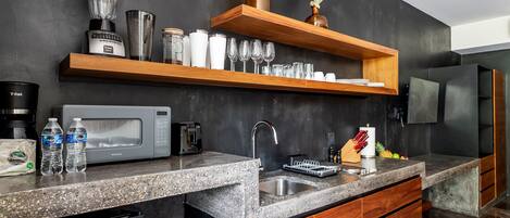 A modern kitchen with granite countertops, wooden cabinets, a built-in microwave, and a stainless steel sink.