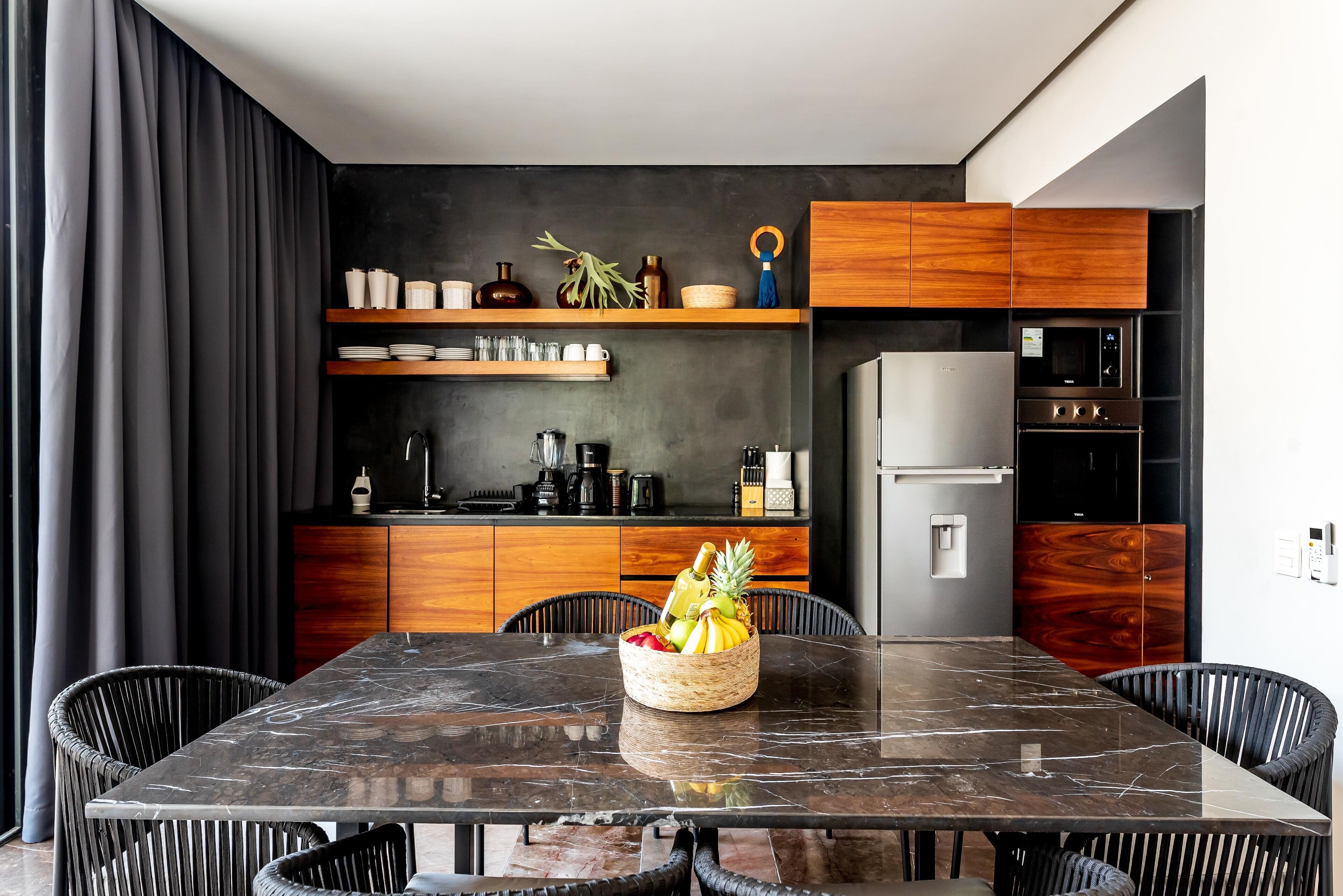 A modern kitchen with wooden cabinets, a built-in microwave, and a refrigerator.