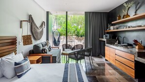 A modern hotel room with a bed, seating area, dining table, and kitchen. - IIK Tulum by The Spot Rentals (Tulum)