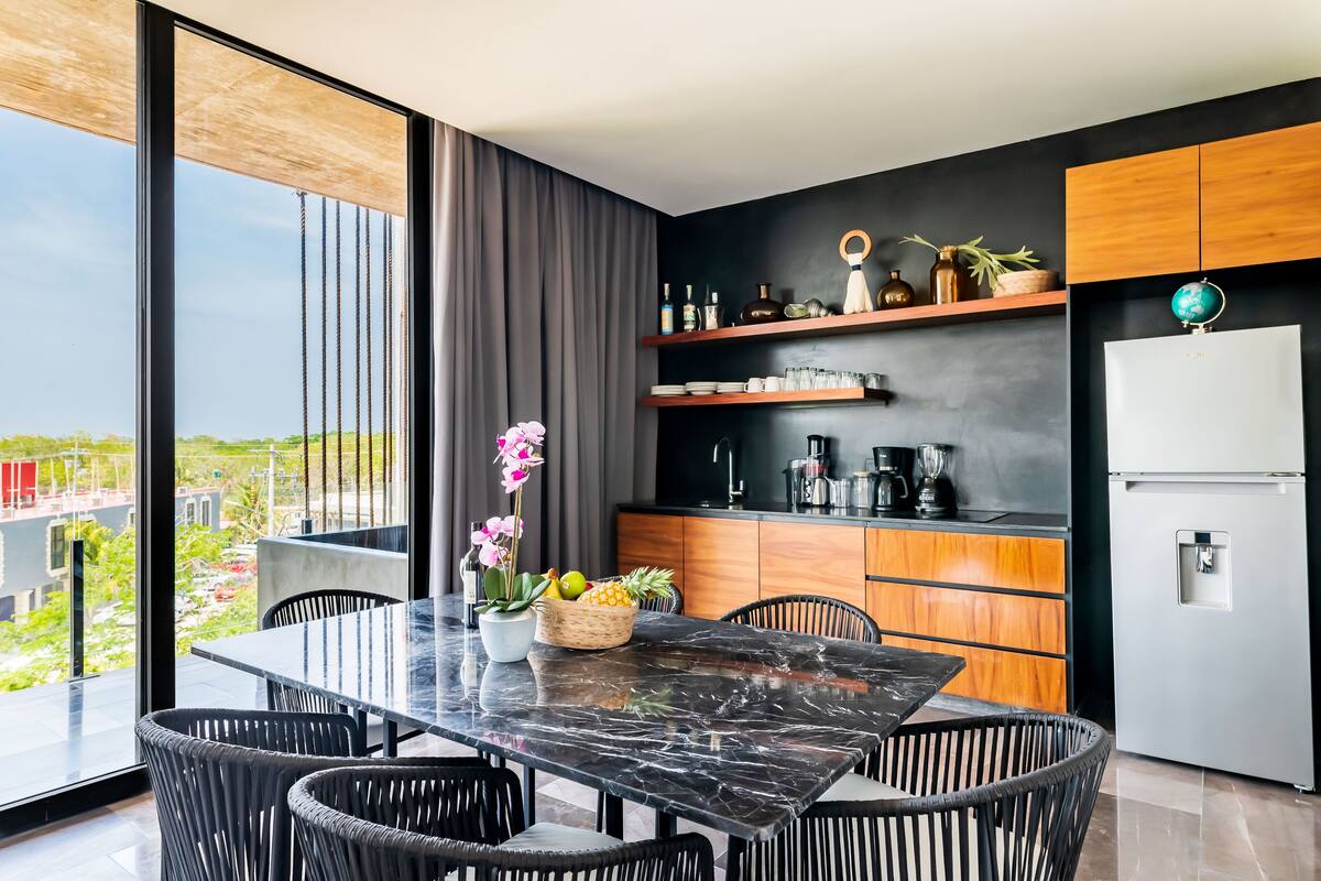 A modern kitchen with a marble countertop, wooden cabinets, and a built-in stove.