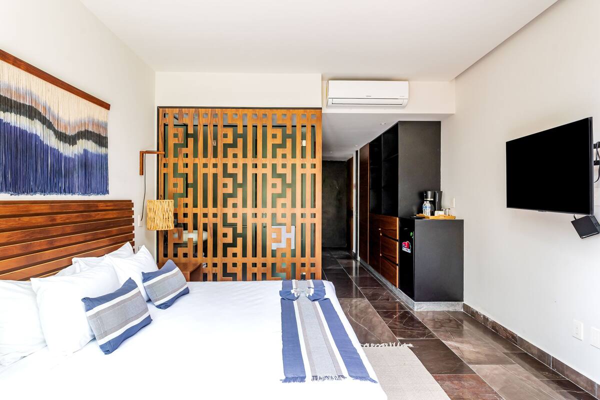 A hotel room with a bed, a TV, a desk, and a wardrobe.