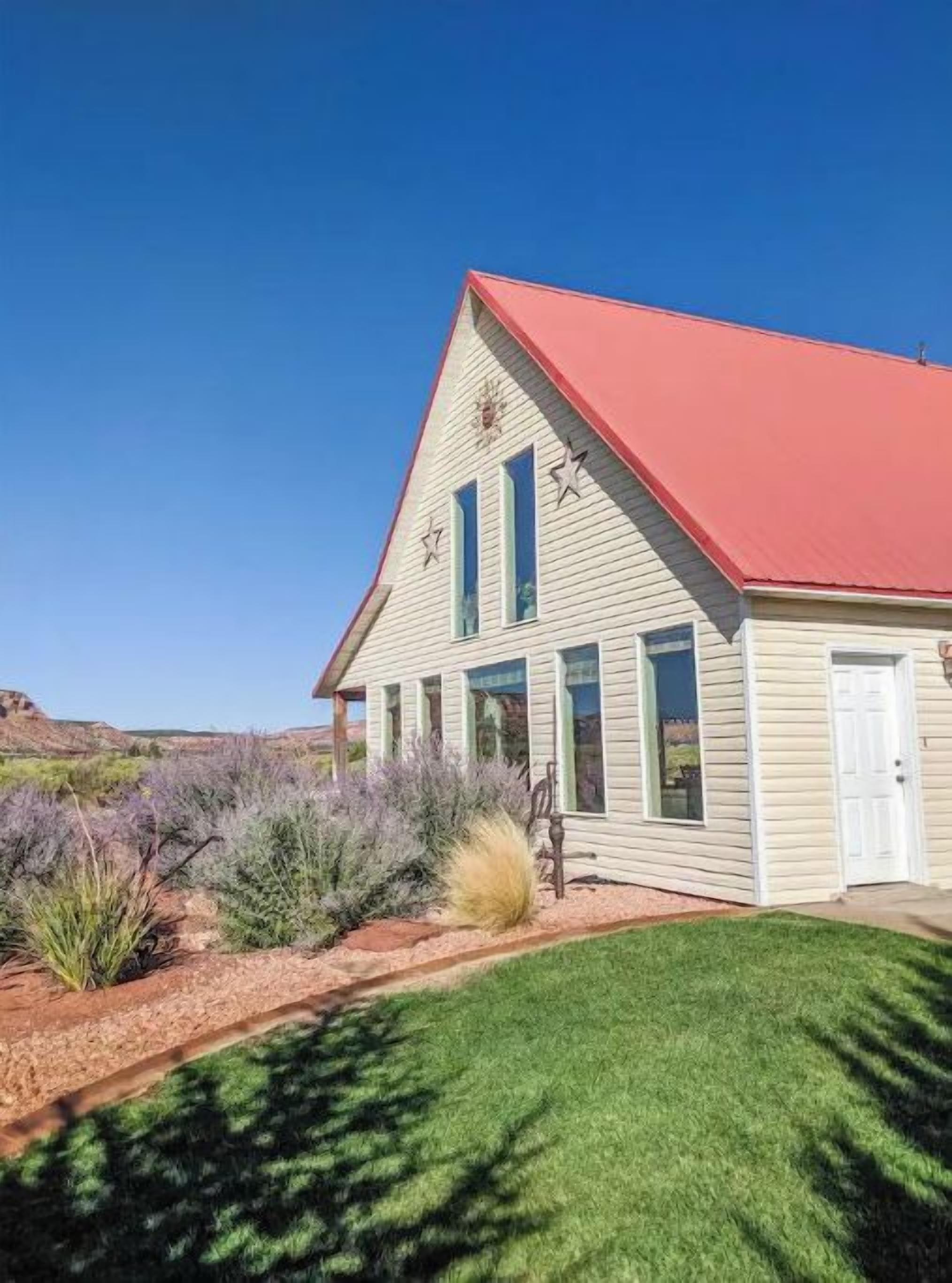 A single-story building with a red roof, white siding, and a small porch.