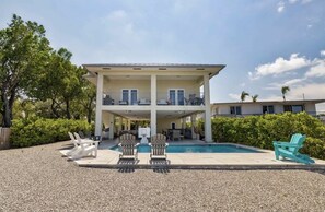 A two-story building with a pool, outdoor seating, and a covered patio area.