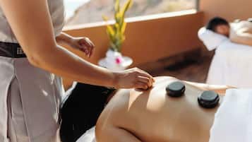 En massageterapeut giver en massage, hvor klienten ligger på maven, mens terapeuten arbejder med et værktøj.