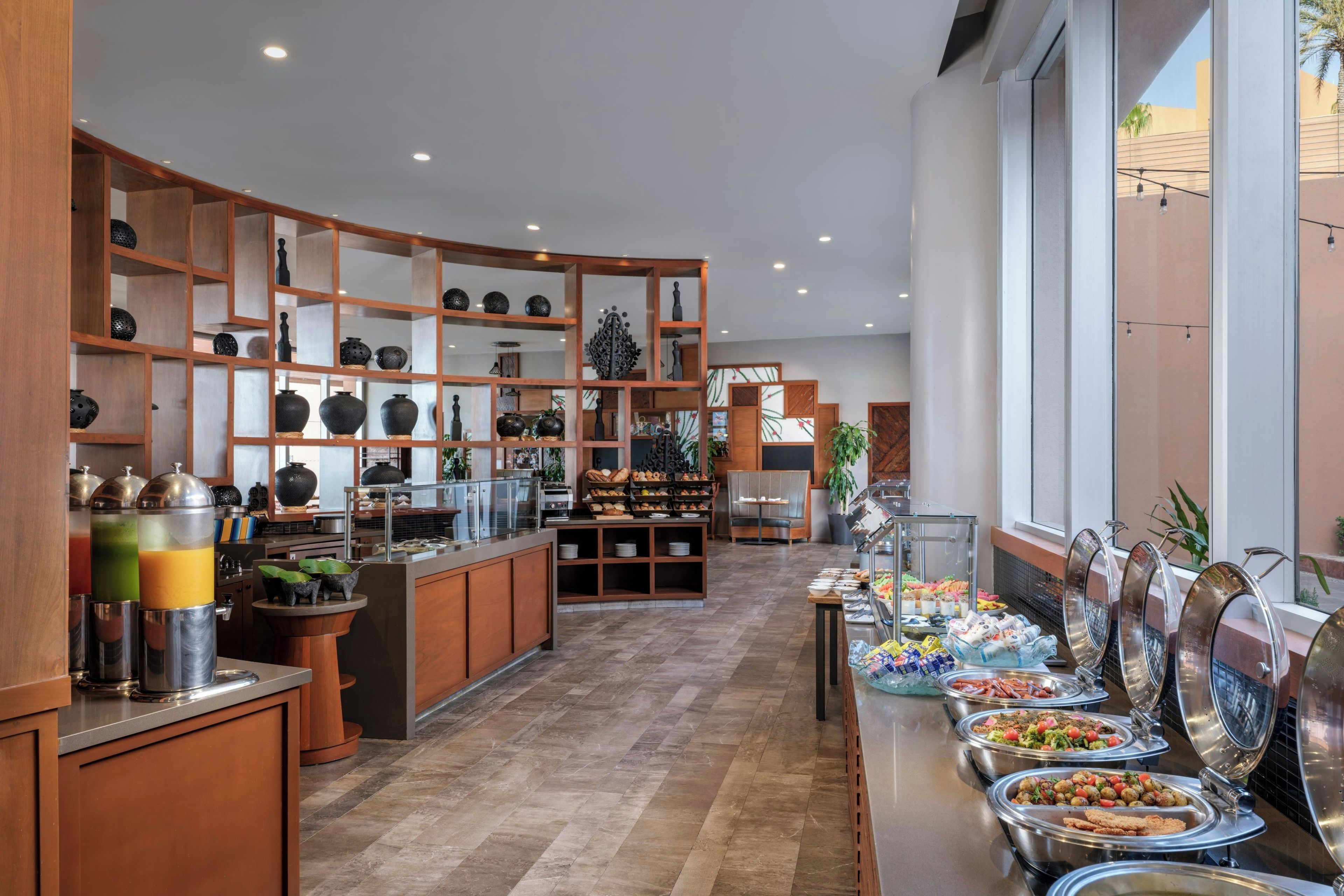 Un área de bufé con diferentes estaciones de comida y una exhibición de objetos decorativos.