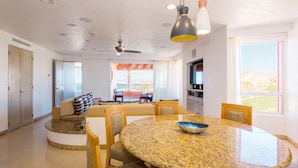 Una cocina moderna con encimera de granito, sillas de madera y una mesa de comedor.