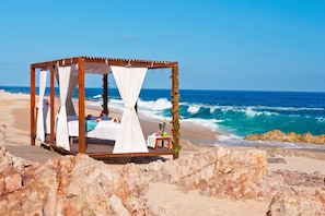 På stranden, vit sandstrand, parasoller och massage på stranden