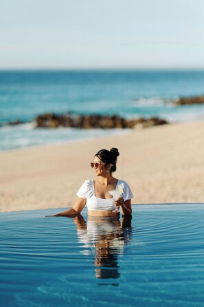 A person in a white top sitting in a clear pool with a view of the beach and ocean. - The Westin Los Cabos Resort Villas - Baja Point (San José del Cabo)