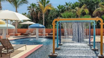 Un espace piscine agrémenté d’un élément décoratif aquatique, de chaises longues et de parasols.