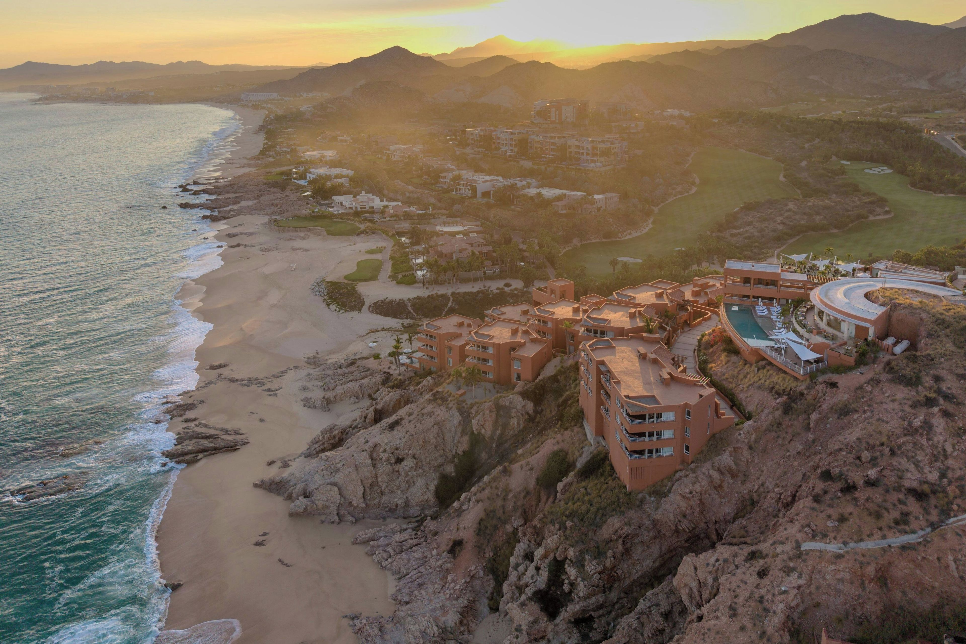 A coastal resort with beachfront villas, a pool, and a golf course.