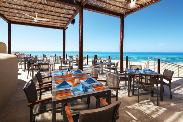 An outdoor dining area with tables and chairs, overlooking the ocean. - The Westin Los Cabos Resort Villas - Baja Point (San José del Cabo)