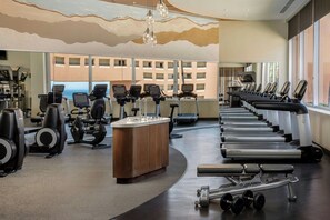 A gym with cardio machines, weightlifting equipment, and a large window with a view of buildings. - The Westin Los Cabos Resort Villas - Baja Point (San José del Cabo)