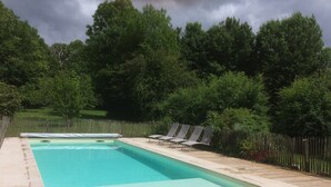 A rectangular swimming pool with a wooden deck and lounge chairs. - Charming country house (Verruyes)