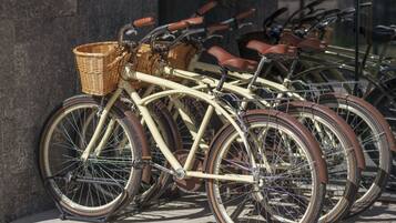 Una hilera de bicicletas antiguas estacionadas contra una pared.