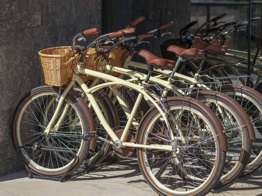 Una hilera de bicicletas antiguas estacionadas contra una pared.