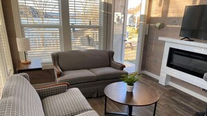 A living room with a sectional sofa, a round coffee table, and a fireplace. - Hales Bar Marina and Resort (Guild)