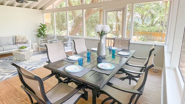 A dining area with a large table, chairs, and a ceiling fan.