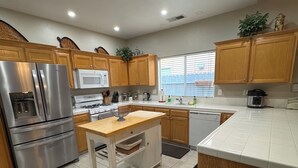 A modern kitchen with wooden cabinets, stainless steel appliances, and a central island.