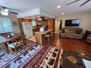 Un amplio espacio de estar con cocina, una mesa de comedor y un sofá.