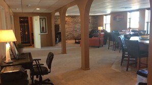 A spacious lobby with a high ceiling, a fireplace, and a dining area with multiple chairs and tables.