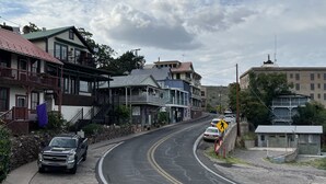 Eine Straße mit Gebäuden, einem Fußgängerübergang und einem parkenden Lastwagen.