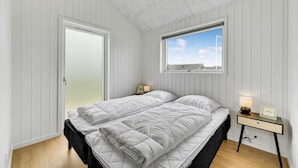 Une chambre à coucher avec un lit, un bureau, une fenêtre et une porte.