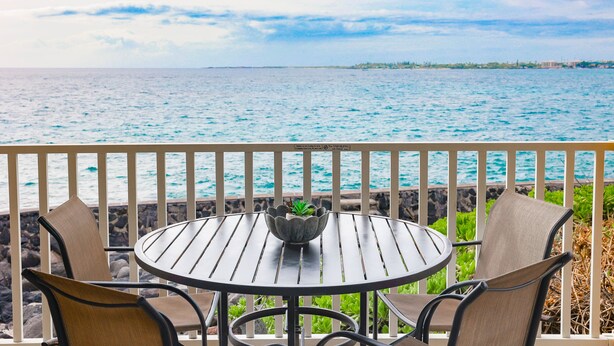 A round table with four chairs, a potted plant, and a view of the ocean. - 🏖️SPECTACULAR - OCEANFRONT - GREAT LOCATION!!!🏖️ (Kailua-Kona)