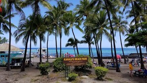 A beach park sign with palm trees and beachgoers. - 🏖️SPECTACULAR - OCEANFRONT - GREAT LOCATION!!!🏖️ (Kailua-Kona)