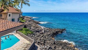 A coastal hotel with a swimming pool, rocky shoreline, and palm trees. - 🏖️SPECTACULAR - OCEANFRONT - GREAT LOCATION!!!🏖️ (Kailua-Kona)